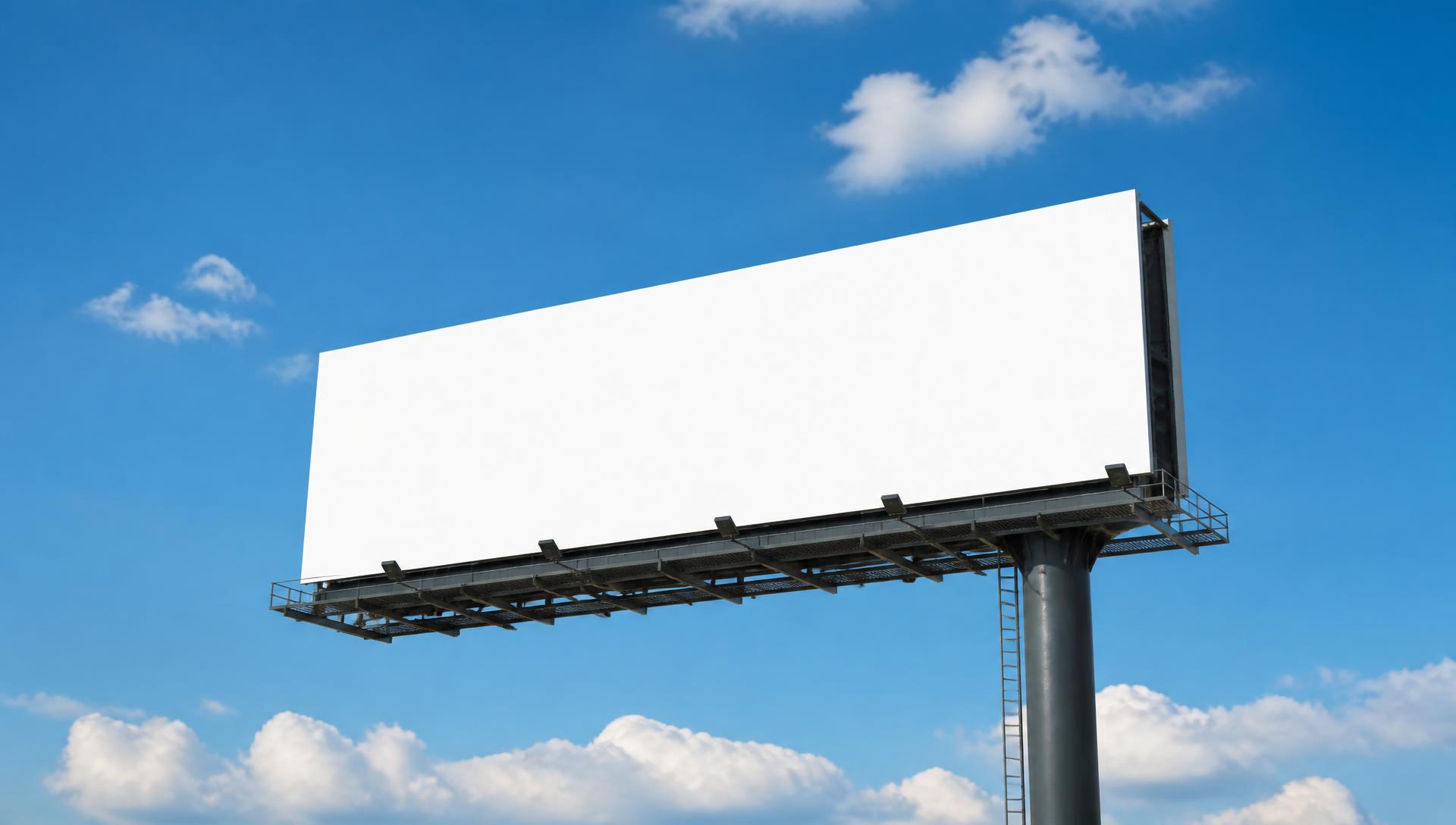 Large highway billboard against a clear blue sky with white clouds